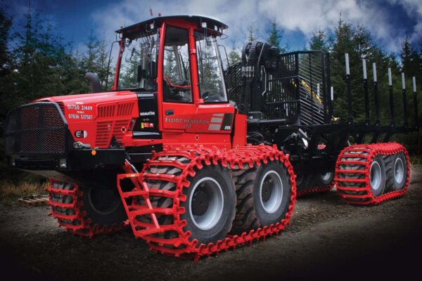 Červené kolopásy Grouzer namontované na ťažkom lesnom stroji Komatsu.