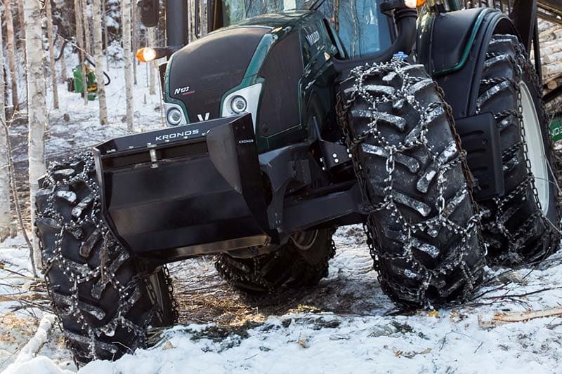 Snehové reťaze na traktor Piggelin Flex namontované na traktore Valtra v zasneženom lese