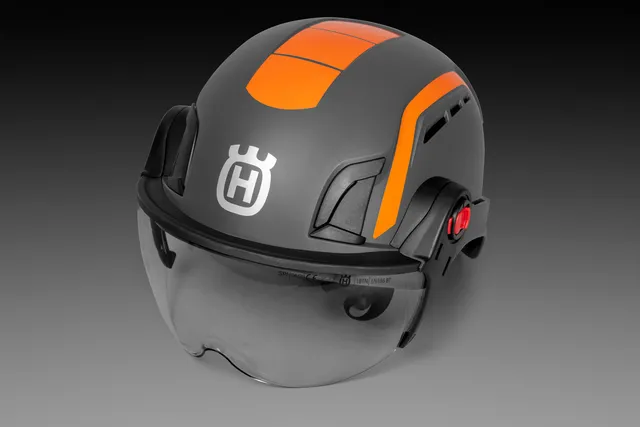 Čelný pohľad na pilčícku prilbu Husqvarna Spire Vent s čírym ochranným hľadím.