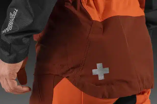 Detailný záber na vrecko pre lekárničku a predĺžený chrbát pilčíckej bundy Husqvarna Technical Extreme