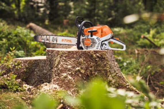 Profesionálna motorová píla STIHL MS 400 C-M VW na pni v lese.