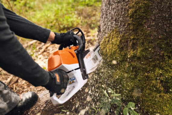 Drevorubač štartuje motorovú pílu STIHL MS 400 C-M v lese.