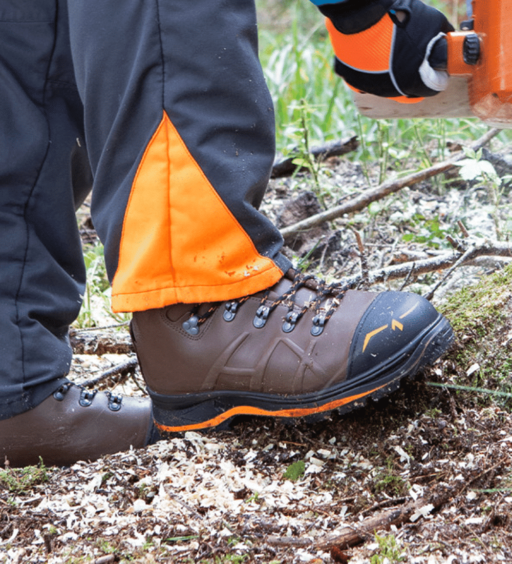 Hnedá pilčícke topánky Haix Trekker Pro 2.0 v teréne pri práci s motorovou pílou.