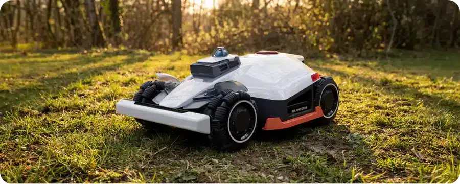 Robotická kosačka Mammotion LUBA 3 AWD bez obvodového kábla v záhrade pri lese.